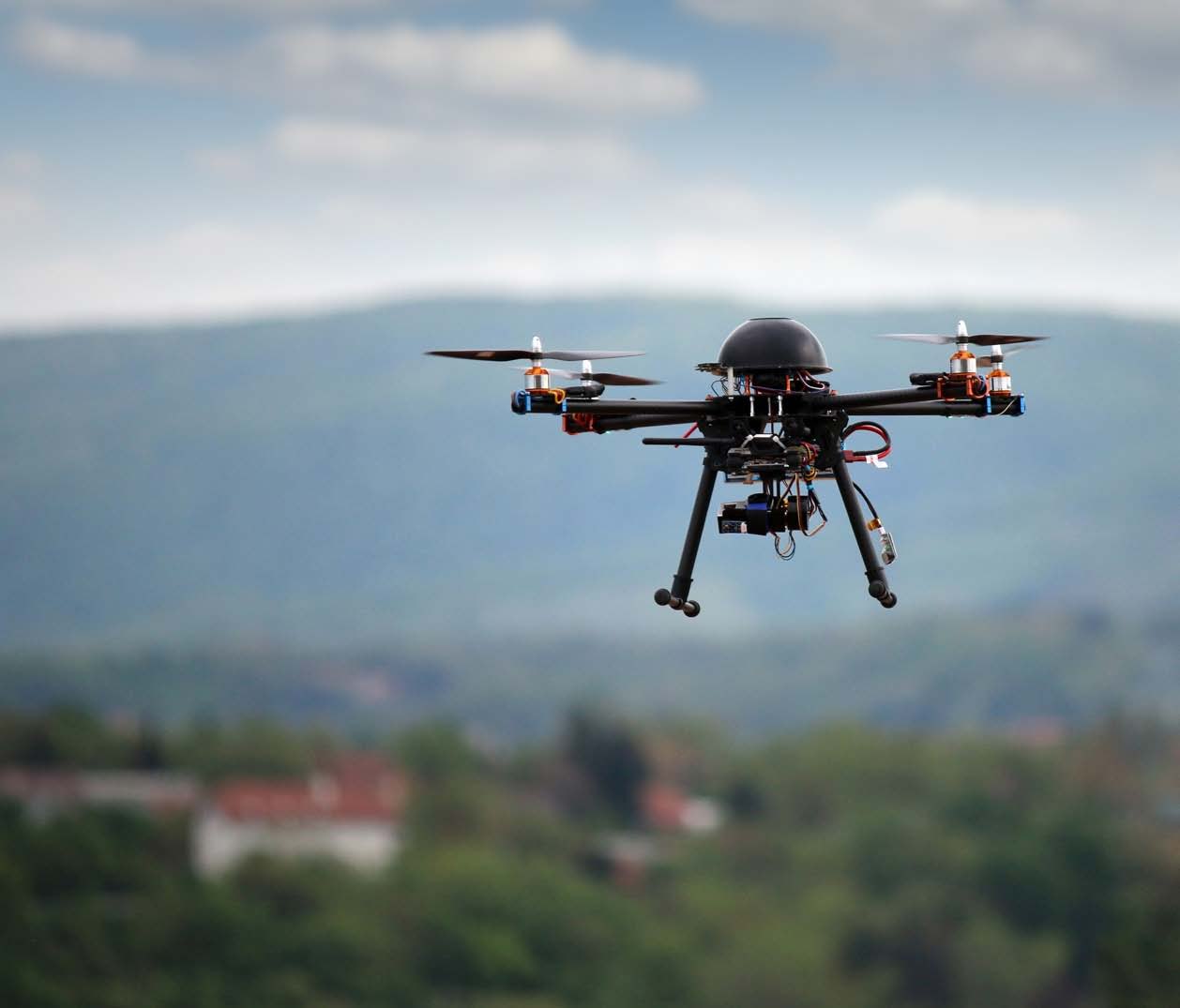 Quadcopter UAV in flight against a hazy landscape